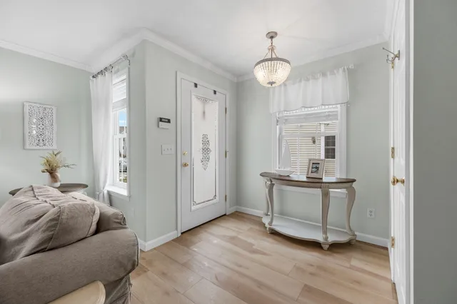 a living room with stainless steel appliances granite countertop furniture and a chandelier