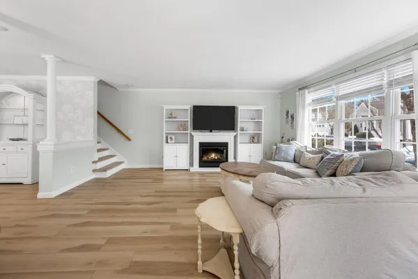 a living room with furniture a fireplace and a large window