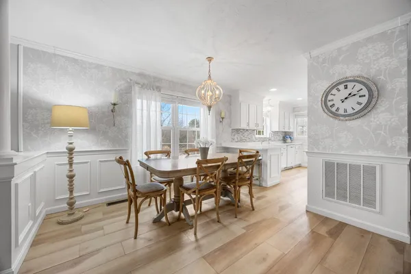 a view of a a dining room with furniture window and wooden floor