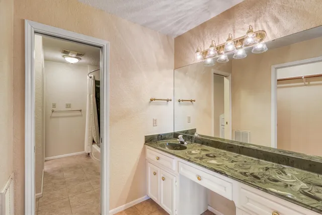 a bathroom with a granite countertop sink a shower and a mirror
