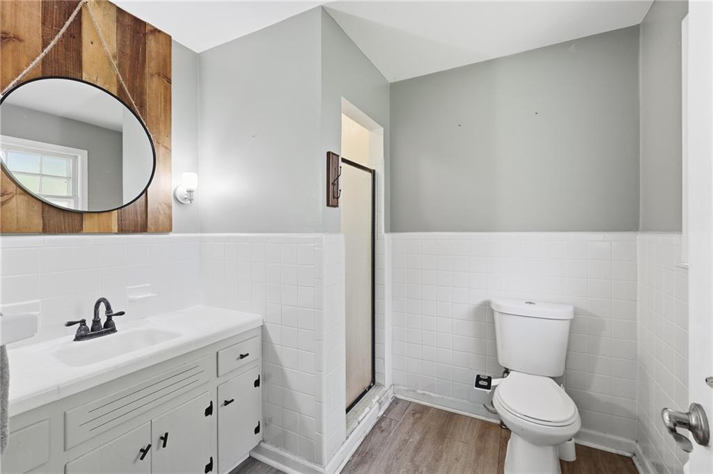 570 Wildcat Bridge Road Royston, GA 30662 - Photo 17 of 29 a bathroom with a toilet a sink a mirror and wooden floor