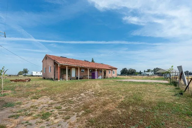a wooden house with a yard and wooden fence