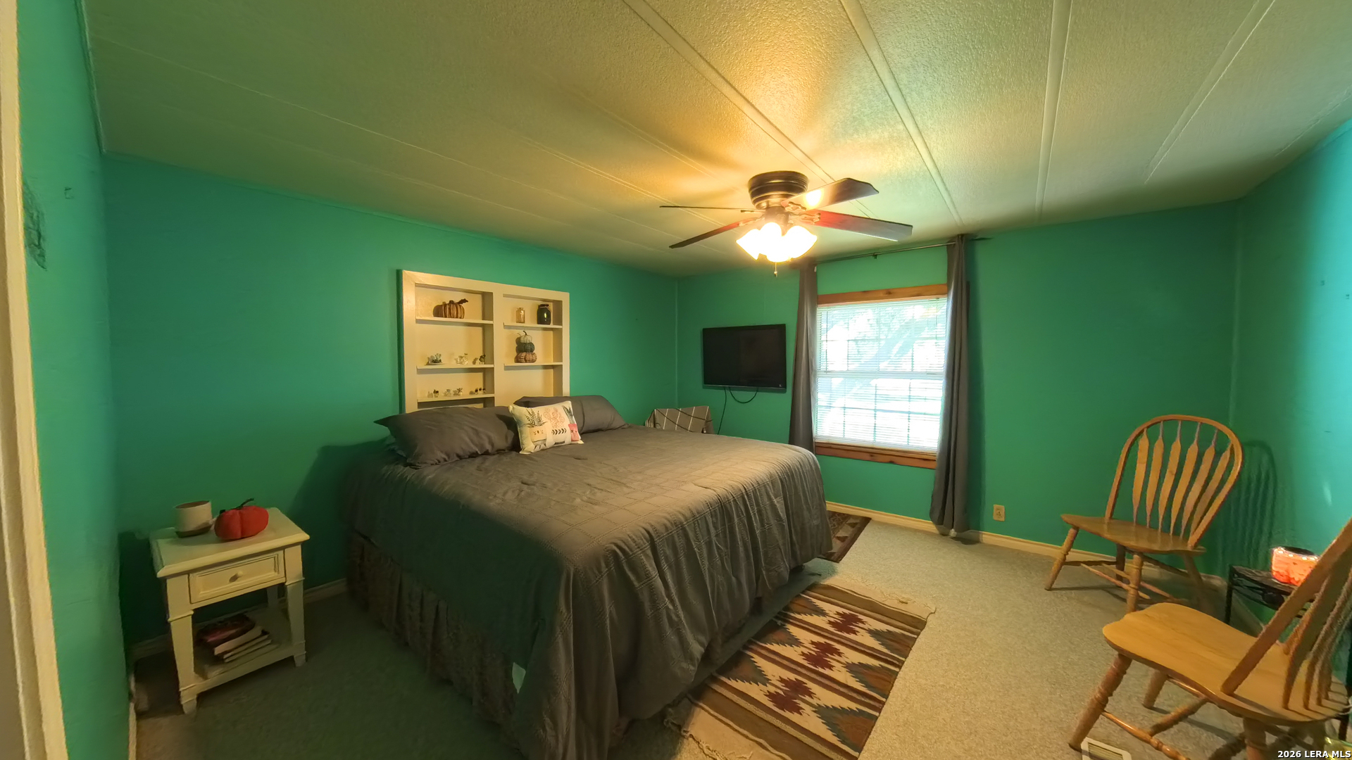 857 Madrona Road Pipe Creek, TX 78063 - Photo 19 of 49 a bedroom with a bed and a chandelier