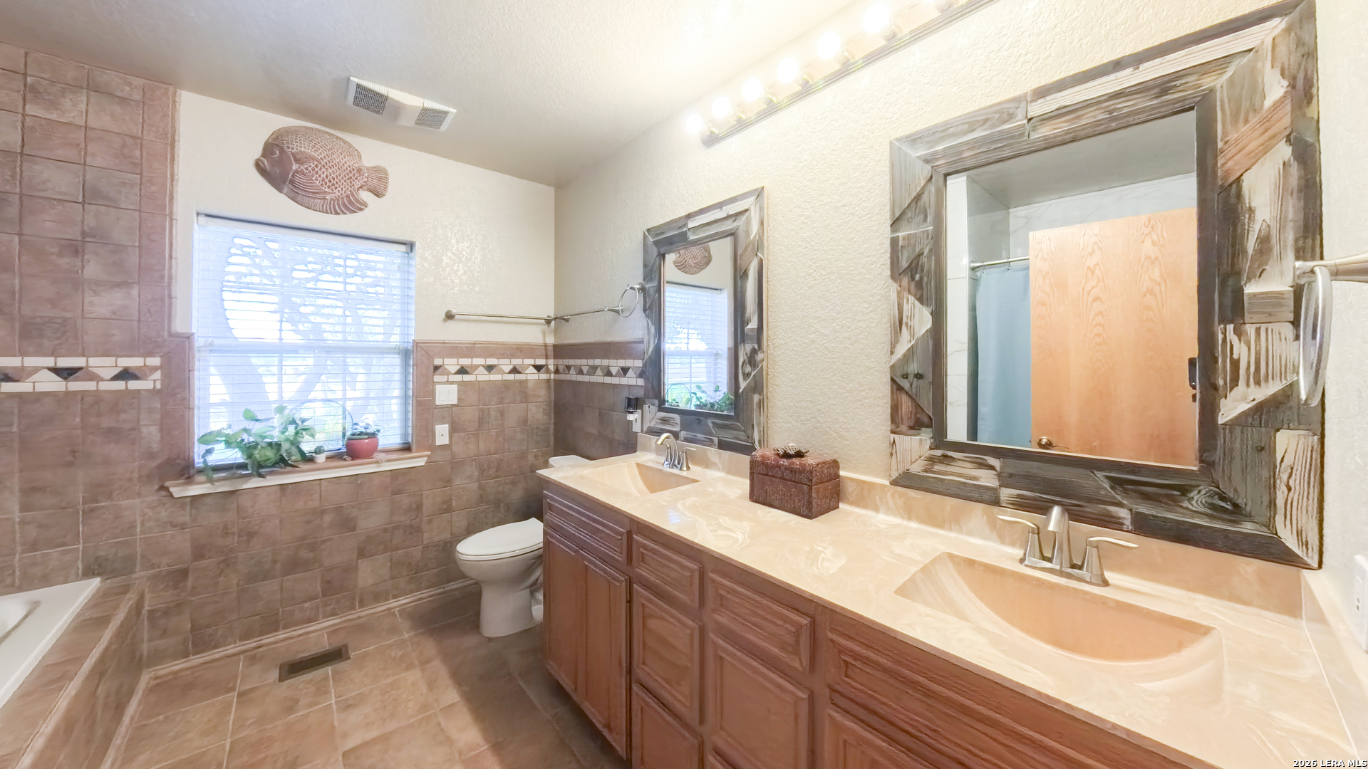 857 Madrona Road Pipe Creek, TX 78063 - Photo 27 of 49 a bathroom with a granite countertop double vanity sink mirror and toilet