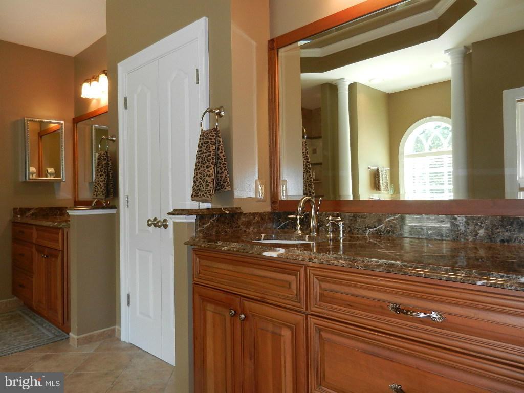 22526 Evergreen Mills Road Ashburn, VA 20148 - Photo 18 of 30 a bathroom with a double vanity sink and a mirror
