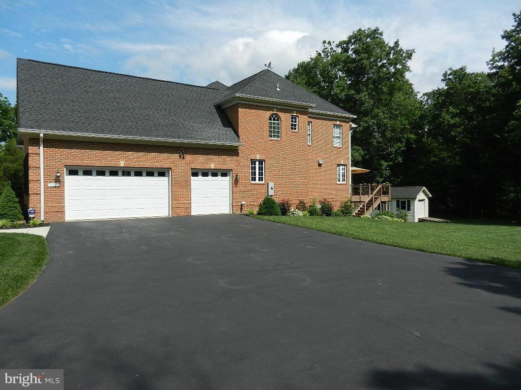 22526 Evergreen Mills Road Ashburn, VA 20148 - Photo 25 of 30 a view of a house with a yard and garage