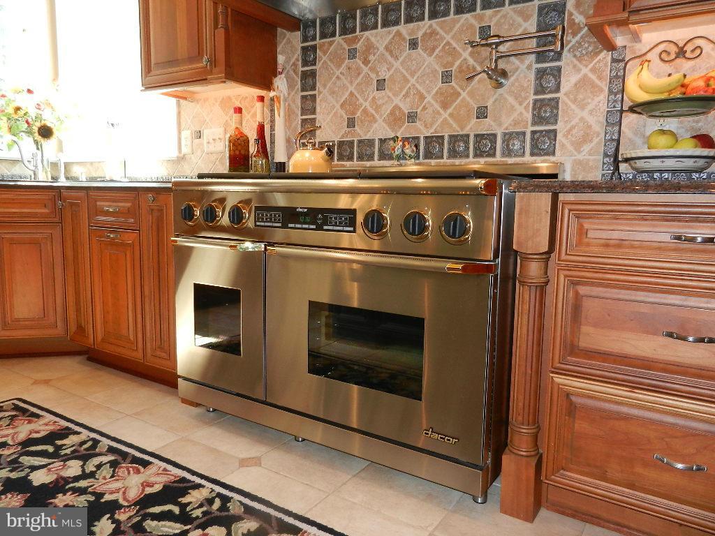 22526 Evergreen Mills Road Ashburn, VA 20148 - Photo 5 of 30 a stove top oven sitting inside of a kitchen