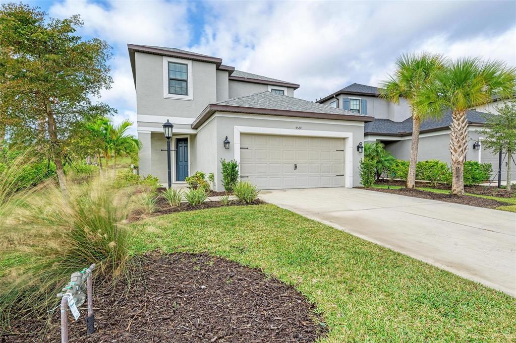 a front view of a house with a garden and plants