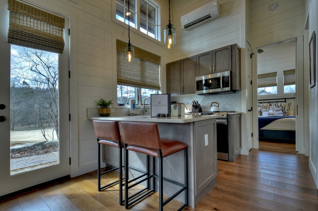 Hc9 Old Toccoa Loop Mineral Bluff, GA 30559 - Photo 17 of 41 a kitchen with stainless steel appliances kitchen island granite countertop a stove a refrigerator a sink a dining table and chairs with wooden floor