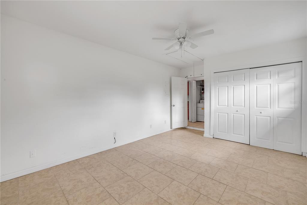 3132 Pine Tree Drive Edgewater, FL 32141 - Photo 19 of 32 an empty room with a ceiling fan and a window