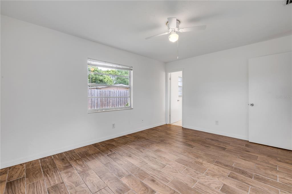 3132 Pine Tree Drive Edgewater, FL 32141 - Photo 26 of 32 wooden floor in an empty room with a window