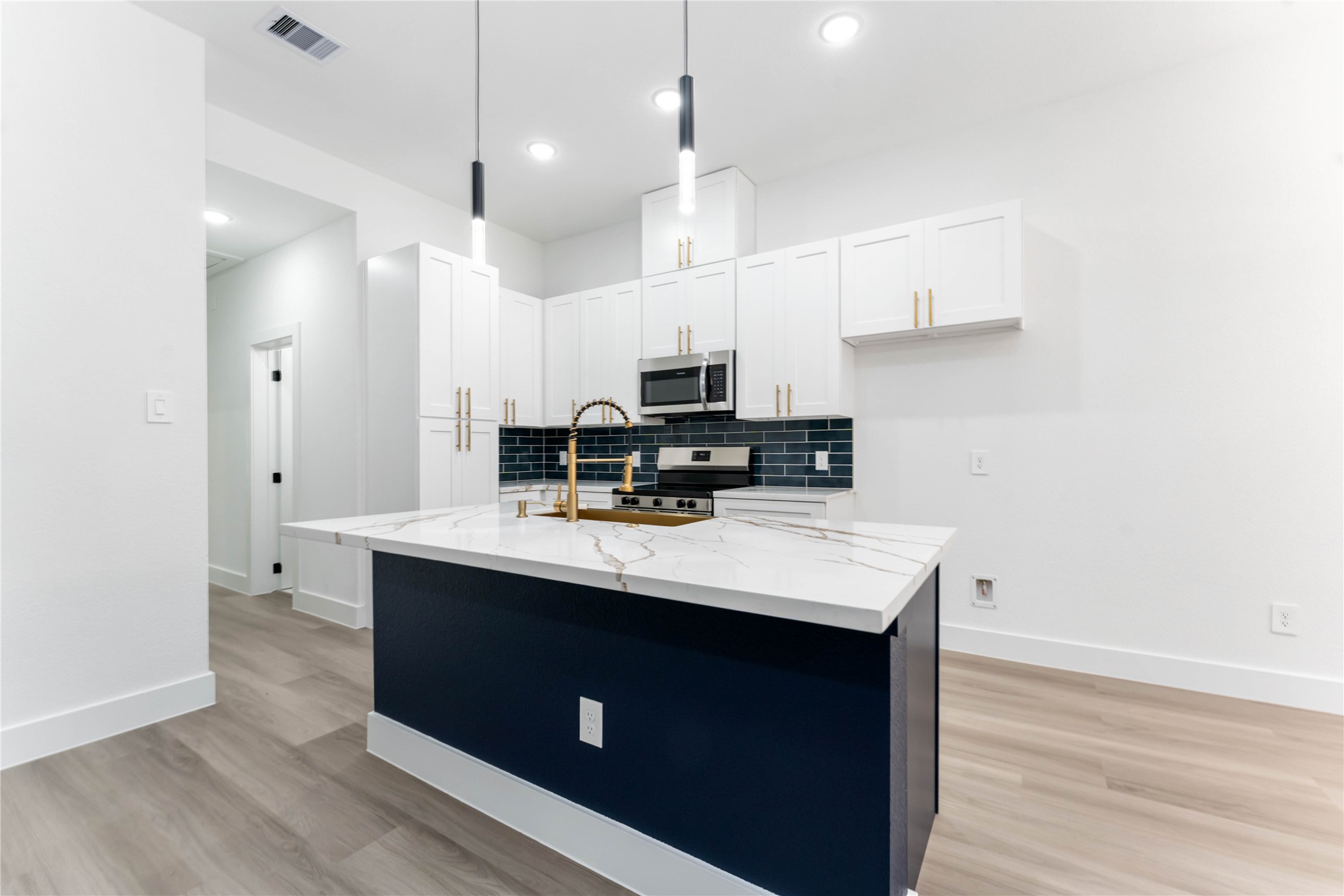 9406 Sandra Street, Unit A Houston, TX 77016 - Photo 12 of 28 a kitchen with kitchen island a sink appliances and wooden floor