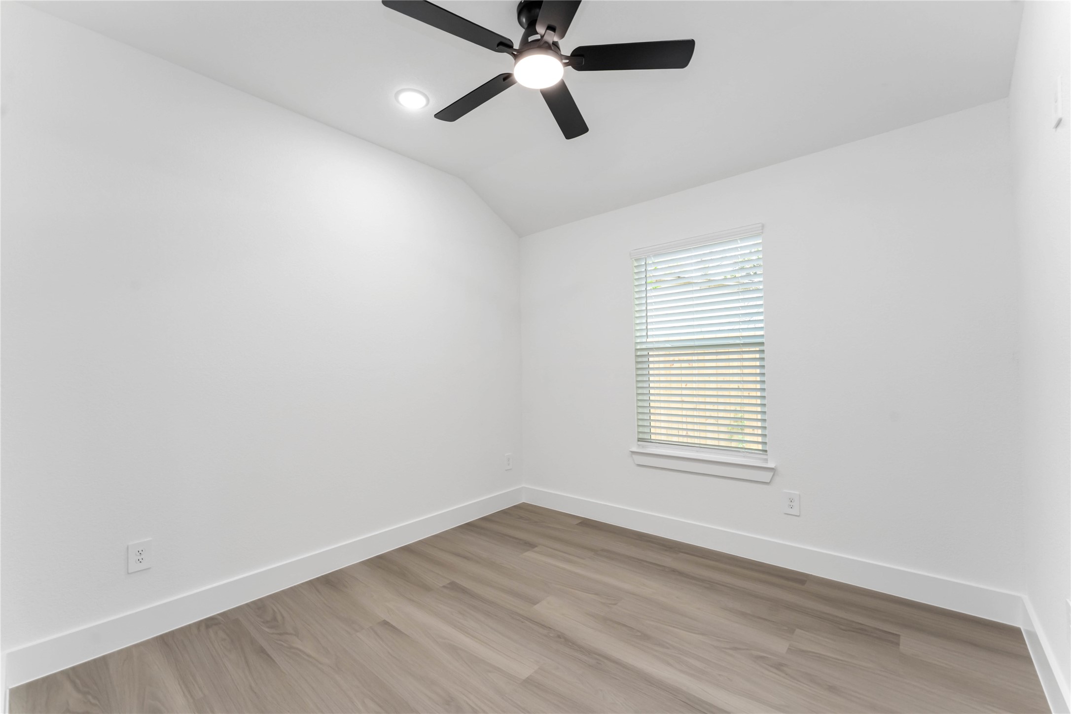 9406 Sandra Street, Unit A Houston, TX 77016 - Photo 16 of 28 an empty room with wooden floor ceiling fan and windows