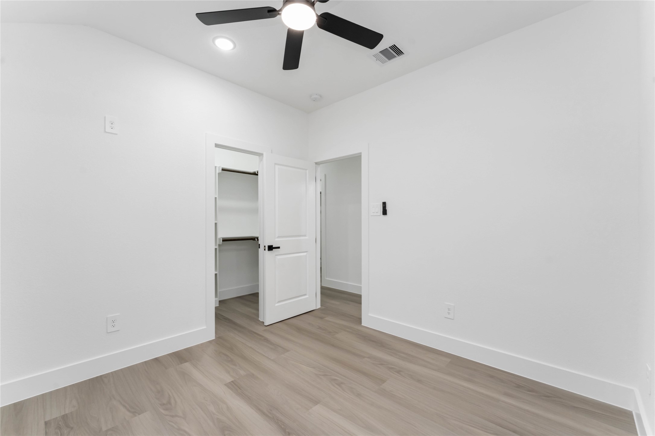 9406 Sandra Street, Unit A Houston, TX 77016 - Photo 17 of 28 an empty room with a ceiling fan and wooden floor