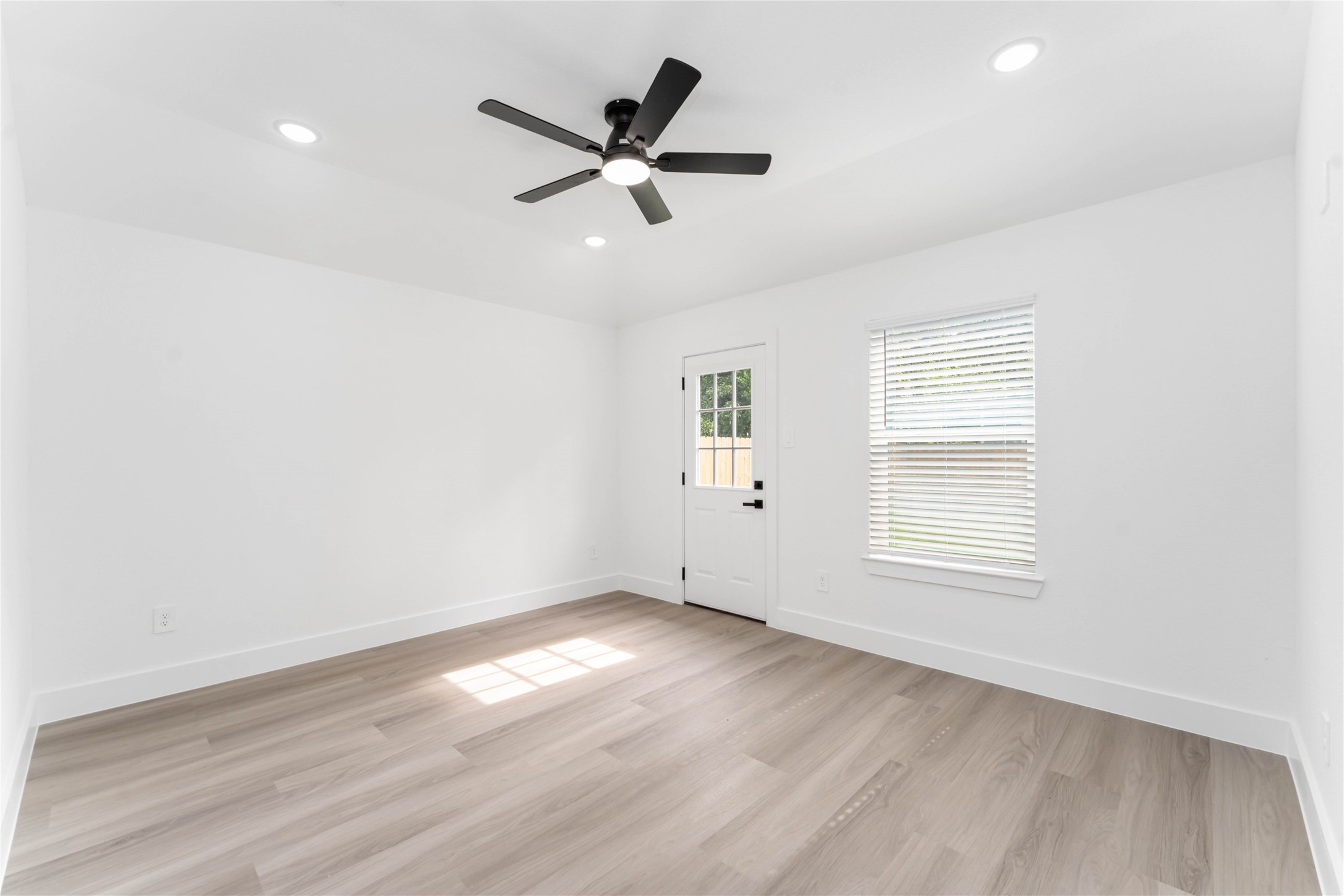 9406 Sandra Street, Unit A Houston, TX 77016 - Photo 21 of 28 an empty room with wooden floor fan and windows