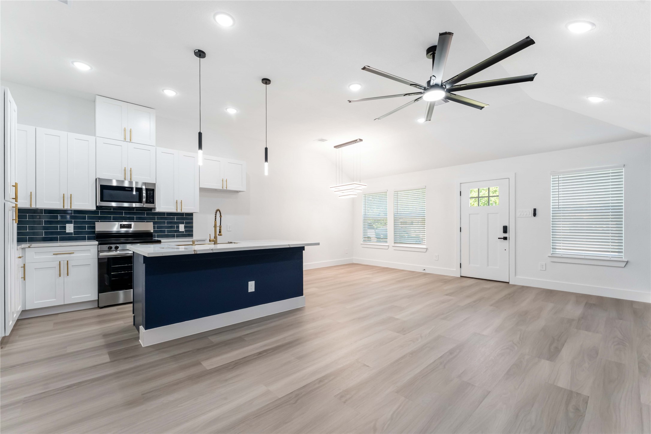 9406 Sandra Street, Unit A Houston, TX 77016 - Photo 10 of 28 a kitchen with stainless steel appliances kitchen island granite countertop a stove a sink a refrigerator and white cabinets with wooden floor