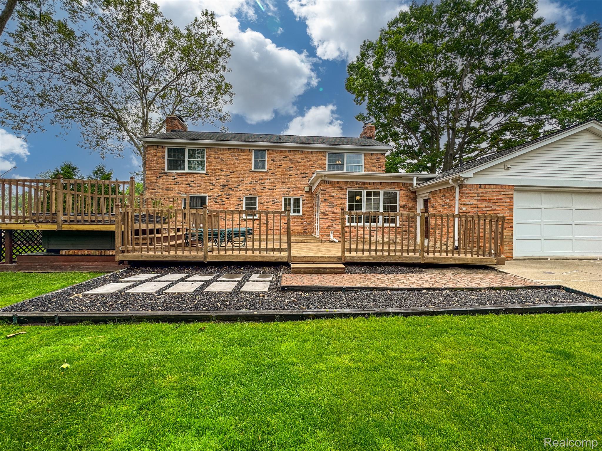 100 Overhill Road Bloomfield Hills, MI 48301 - Photo 43 of 55 Rear view of property featuring a deck, a chimney, a lawn, and brick siding