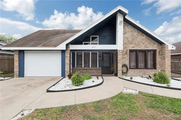 a front view of a house with a garden and plants