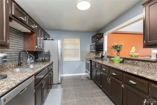 a kitchen with stainless steel appliances granite countertop sink stove and granite counter top