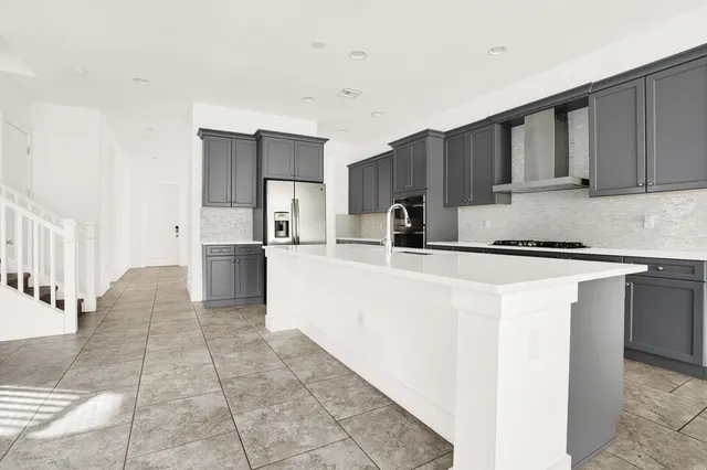 a kitchen with stainless steel appliances a refrigerator sink and cabinets