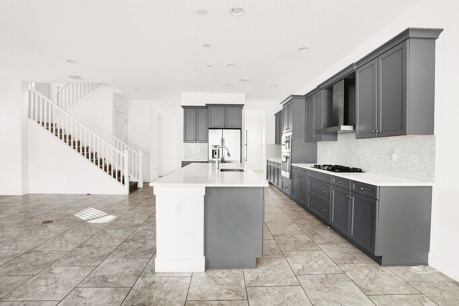 13628 Dumont Road Palm Beach Gardens, FL 33418 - Photo 15 of 44 a large white kitchen with a sink a microwave and cabinets