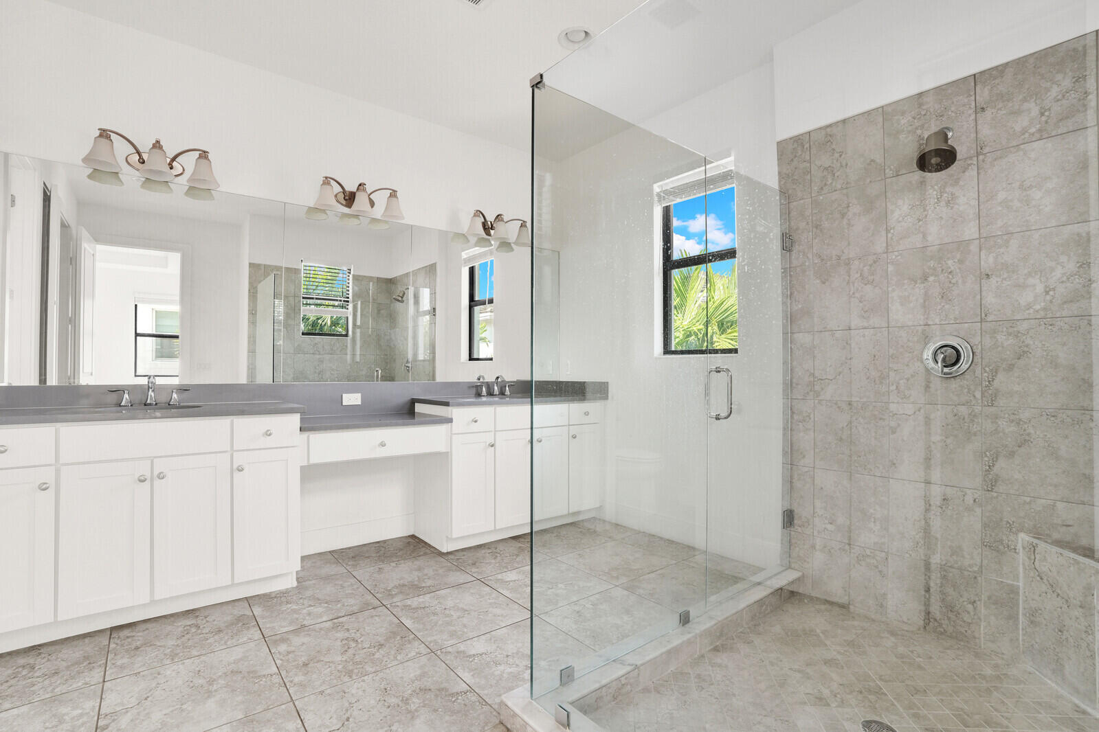 13628 Dumont Road Palm Beach Gardens, FL 33418 - Photo 26 of 44 a spacious bathroom with a granite countertop sink a mirror and a shower