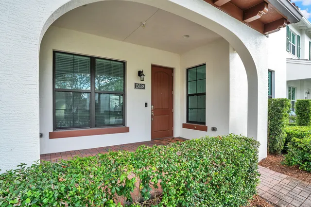 front view of a house with a large window and potted plants