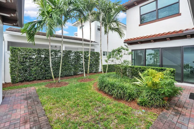 front view of a house with a big yard and potted plants