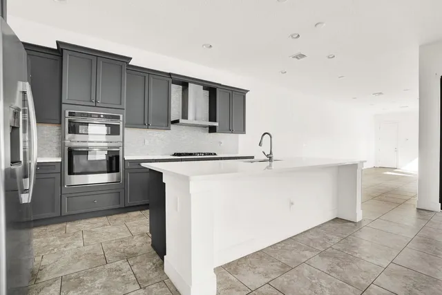 a kitchen with stainless steel appliances a sink and a refrigerator