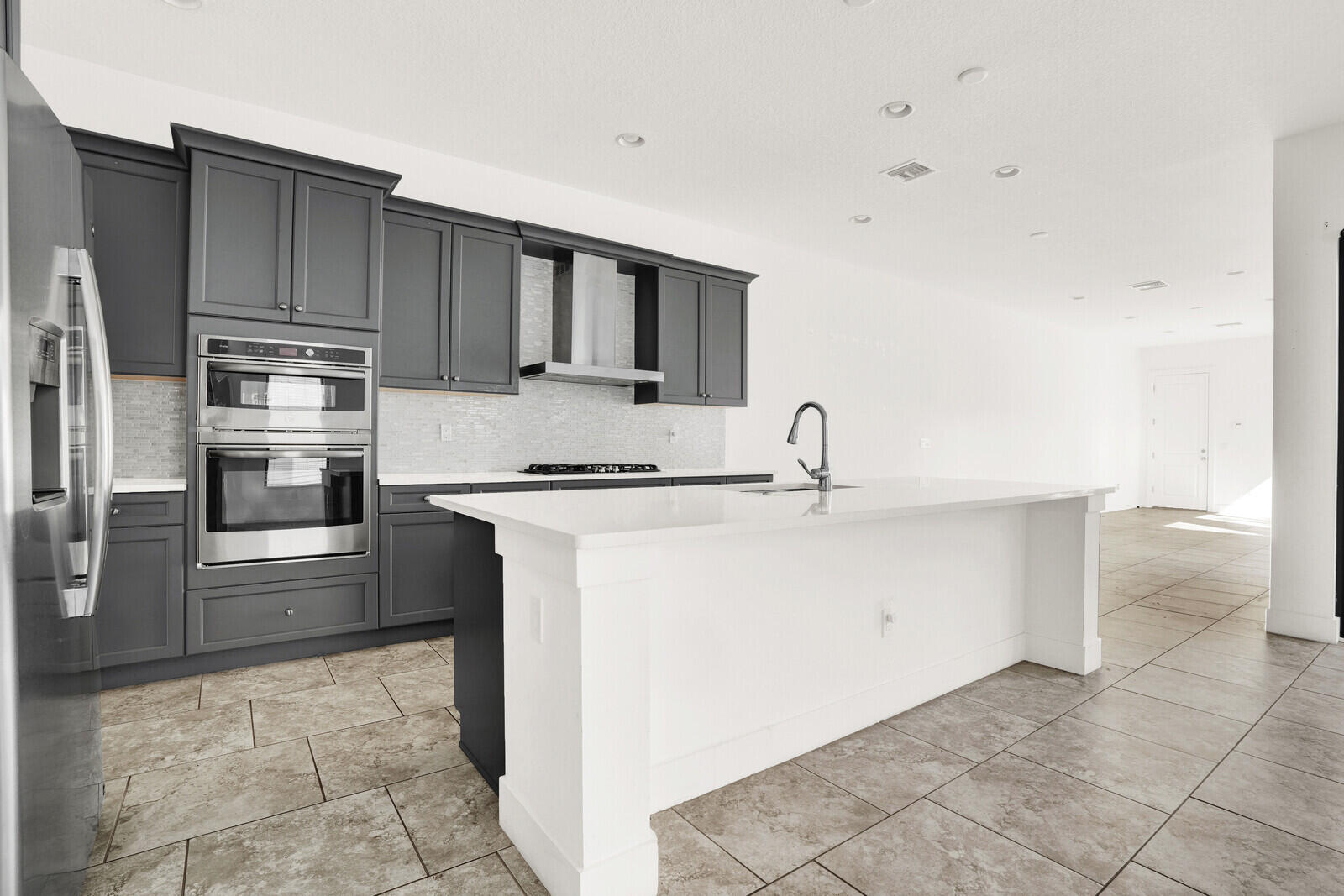 13628 Dumont Road Palm Beach Gardens, FL 33418 - Photo 9 of 44 a kitchen with stainless steel appliances a sink and a refrigerator