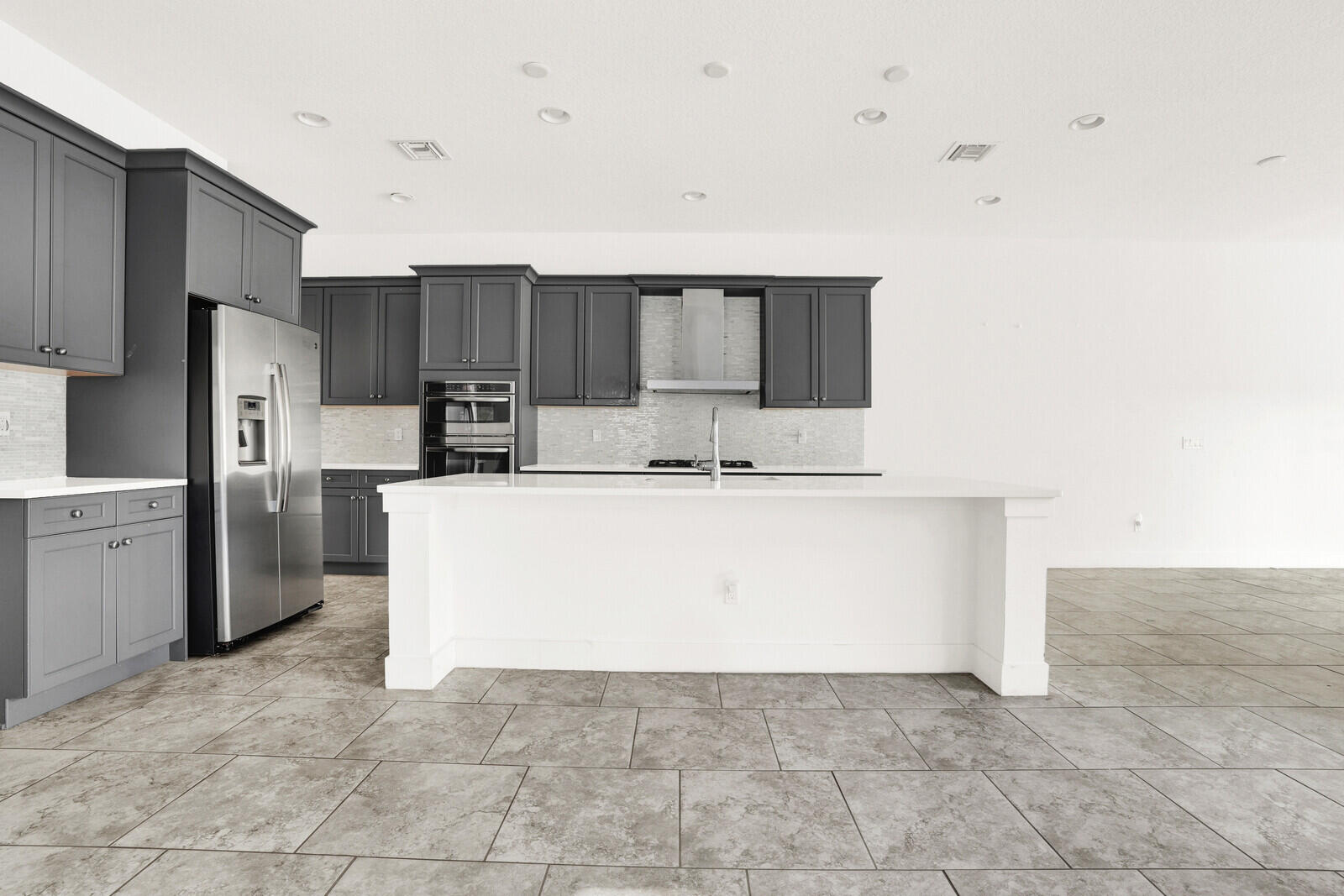 13628 Dumont Road Palm Beach Gardens, FL 33418 - Photo 10 of 44 a large kitchen with cabinets and stainless steel appliances