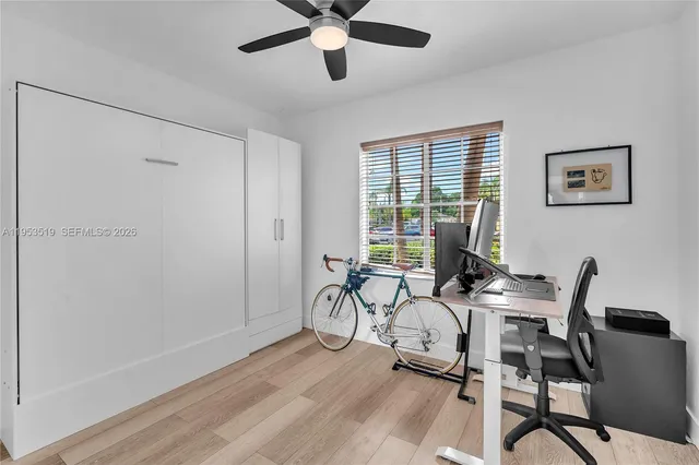 a view of a workspace with furniture and a window
