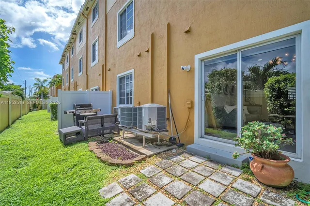 a view of a patio with chairs and potted plants