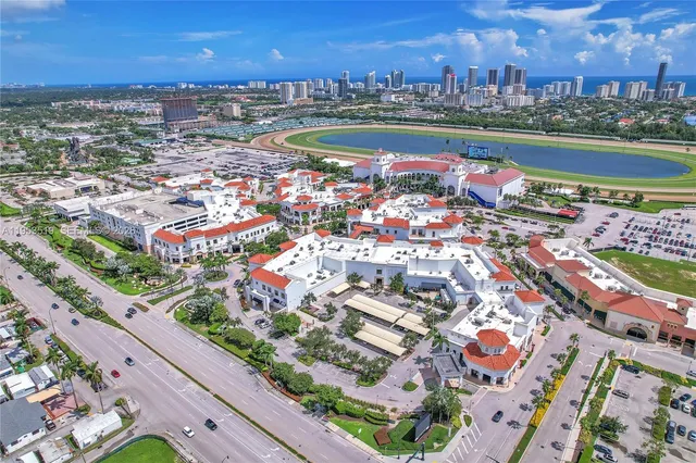 an aerial view of a city with lots of residential buildings ocean and mountain view in back
