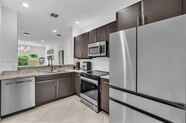 a kitchen with stainless steel appliances granite countertop a refrigerator and a sink