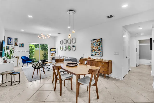 a dining room with furniture and a large window