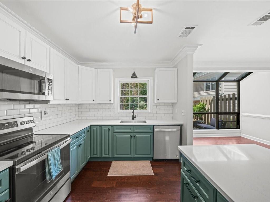 a kitchen with a sink appliances and cabinets