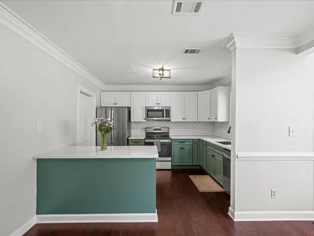 a kitchen with a sink cabinets and wooden floor