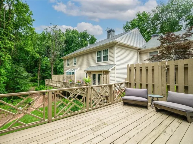 a view of a house with wooden deck and furniture