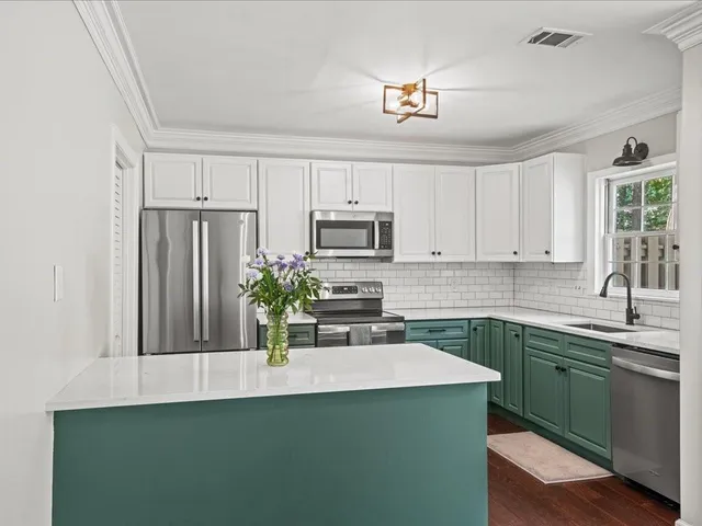a kitchen with a sink a microwave a stove and refrigerator
