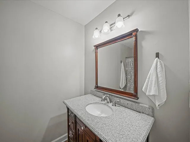 a bathroom with a granite countertop sink a mirror and a vanity