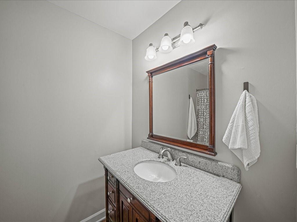 50 Mt Vernon Circle Atlanta, GA 30338 - Photo 24 of 28 a bathroom with a granite countertop sink a mirror and a vanity
