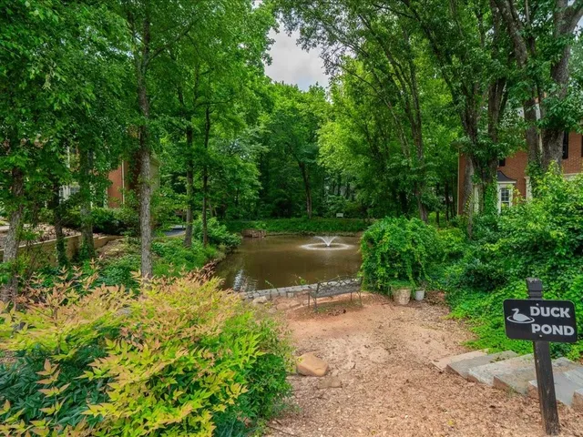 a view of lake background with table and chairs and wooden fence
