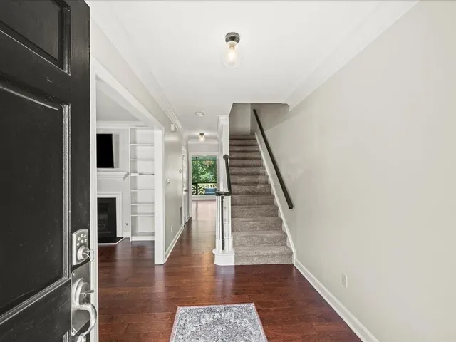 a view of a hallway with wooden floor and staircase