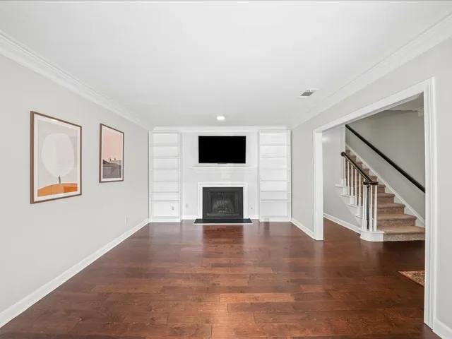 a view of a livingroom with wooden floor and a fireplace