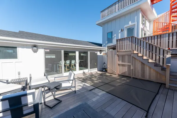 a view of a house with backyard sitting area and wooden floor