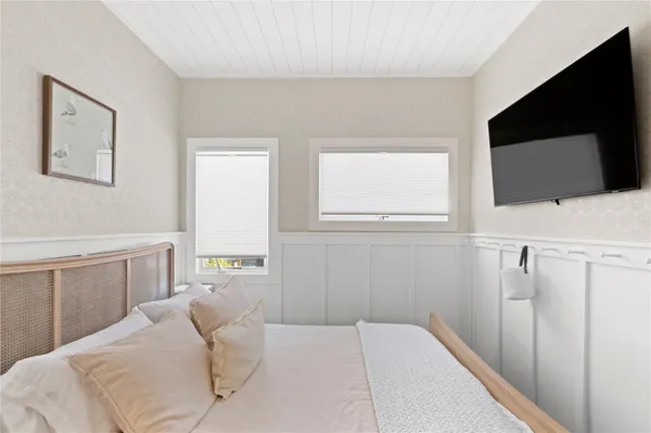 a bedroom with a bed and a flat screen tv