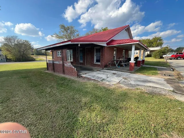 a view of a house with a yard and sitting area