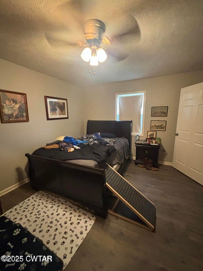 52 South Pleasant Street Decaturville, TN 38329 - Photo 28 of 46 a bedroom with a bed and a chandelier