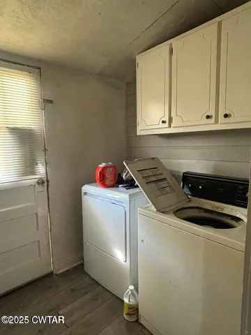a utility room with cabinets washer and dryer